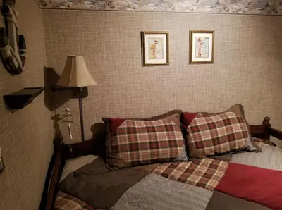a bedroom with a bed and two pictures on the wall at Lambs Landing Huron Family Vacation Home in Huron