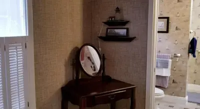 a bathroom with a mirror on a table and a toilet at Lambs Landing Huron Family Vacation Home in Huron