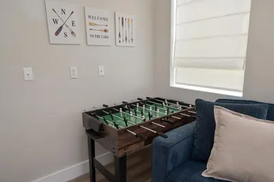 a foosball table in a living room with a blue couch at Modern Lake House 3 Blocks from the Lake! in Buckeye Lake