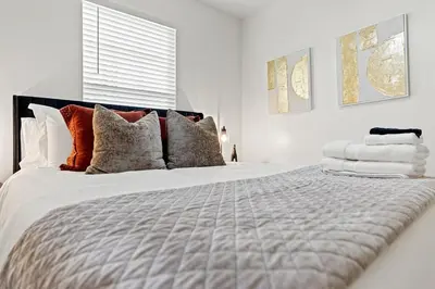 a white bedroom with a large bed with pillows at The Luxe Hot Tub Playground 12 Min to Horse Park in Georgetown