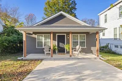 a house with two chairs on a porch at The Luxe Hot Tub Playground 12 Min to Horse Park in Georgetown