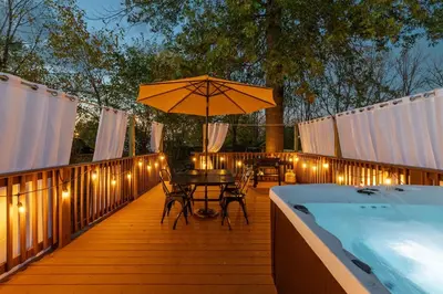 a deck with a table and an umbrella and a pool at The Luxe Hot Tub Playground 12 Min to Horse Park in Georgetown