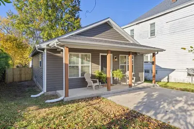 a house with a porch with a chair on it at The Luxe Hot Tub Playground 12 Min to Horse Park in Georgetown