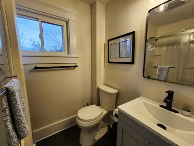 a bathroom with a toilet and a sink and a mirror at The Farmhouse in Elyria, OH in Elyria
