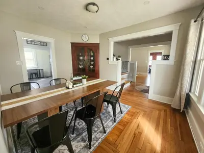a dining room with a large wooden table and chairs at The Farmhouse in Elyria, OH in Elyria