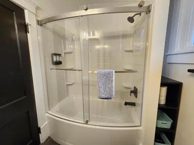 a shower with a glass door in a bathroom at The Farmhouse in Elyria, OH in Elyria