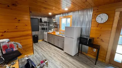 a kitchen with a refrigerator and a clock on the wall at Hot tub - Near the Gorge and Cave Run in Wellington
