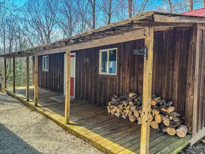 a wooden cabin with a bunch of logs inside at Hot tub - Near the Gorge and Cave Run in Wellington