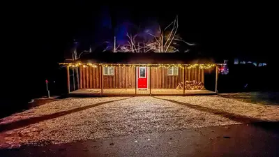 a house with a red door with christmas lights at Hot tub - Near the Gorge and Cave Run in Wellington