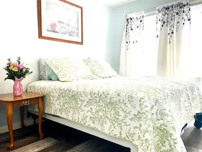a bed in a bedroom with a vase on a table at Emerald - GREAT PARK, 3br, Yard, Pet-Friendly in Paulding