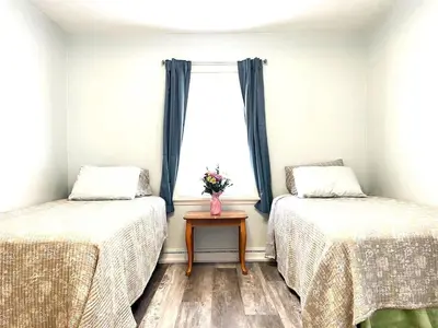 a room with two beds and a window with a table at Emerald - GREAT PARK, 3br, Yard, Pet-Friendly in Paulding
