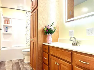 a bathroom with a sink and a toilet and a vase of flowers at Emerald - GREAT PARK, 3br, Yard, Pet-Friendly in Paulding