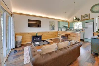 a living room with a couch and a kitchen at Hot Tub and Fire Pit Romantic Getaway in Frenchburg in Frenchburg