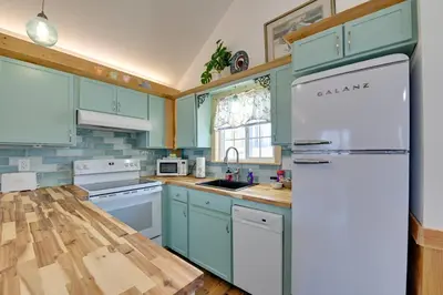 a kitchen with blue cabinets and a white refrigerator at Hot Tub and Fire Pit Romantic Getaway in Frenchburg in Frenchburg