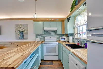 a kitchen with blue cabinets and white appliances at Hot Tub and Fire Pit Romantic Getaway in Frenchburg in Frenchburg