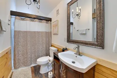 a bathroom with a sink and a toilet and a mirror at Hot Tub and Fire Pit Romantic Getaway in Frenchburg in Frenchburg