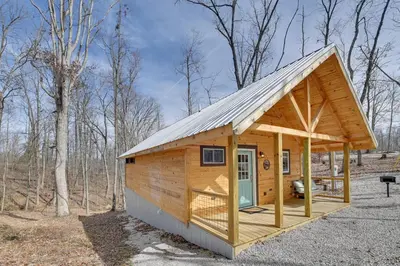 a cabin in the woods with a gambrel roof at Hot Tub and Fire Pit Romantic Getaway in Frenchburg in Frenchburg