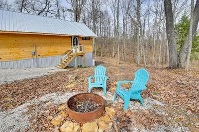 two chairs and a fire pit in front of a cabin at Hot Tub and Fire Pit Romantic Getaway in Frenchburg in Frenchburg