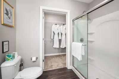 a bathroom with a toilet and a glass shower stall at City View Designer Elevator Covered Parking in Columbus