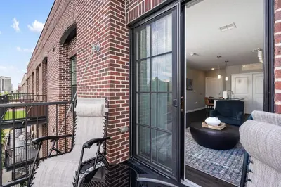 a balcony with a large glass door on a brick building at City View Designer Elevator Covered Parking in Columbus