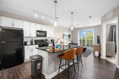 a kitchen with white cabinets and a black refrigerator at City View Designer Elevator Covered Parking in Columbus