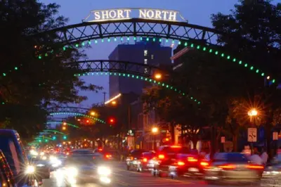a busy city street with cars driving under a street sign at Near Osu Riverside No Steps Garage Parking! in Columbus
