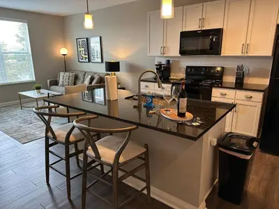 a kitchen with a counter and stools in a room at Near Osu Riverside No Steps Garage Parking! in Columbus
