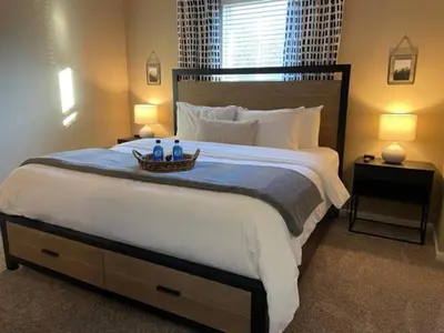 a bedroom with a large white bed with a basket on it at The Hilliard Executive No Steps Luxury Beds in Dublin
