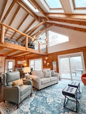 a living room with two couches and a vaulted ceiling at Cabin Sweet Cabin in Burlington