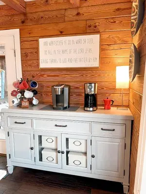 a white dresser in a room with a wooden wall at Cabin Sweet Cabin in Burlington