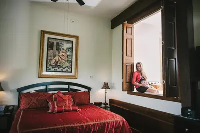 a woman is looking out the window of a bedroom at The Inn at Dresden in Dresden