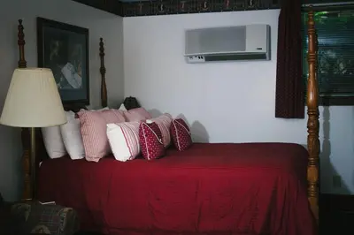 a bedroom with a bed with red sheets and pillows at The Inn at Dresden in Dresden