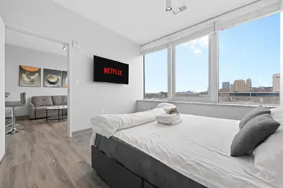 a bedroom with a bed with a view of a city at Luxe Condo in Downtown Cleveland l 2 TV's l Parking in Cleveland