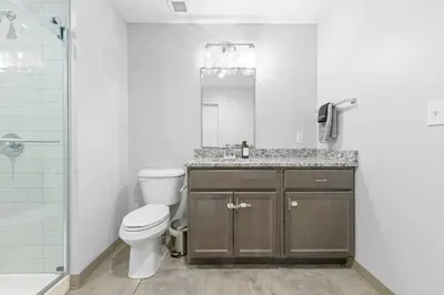a bathroom with a toilet and a sink and a shower at Luxe Condo in Downtown Cleveland l 2 TV's l Parking in Cleveland