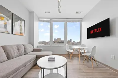 a living room with a couch and a table at Luxe Condo in Downtown Cleveland l 2 TV's l Parking in Cleveland