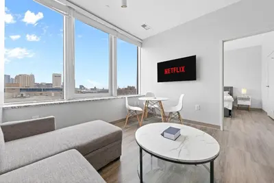 a living room with a couch and a table at Luxe Condo in Downtown Cleveland l 2 TV's l Parking in Cleveland