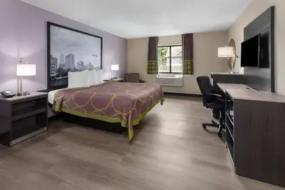 a hotel room with a bed and a desk at Super 8 by Wyndham Copley Akron in Copley