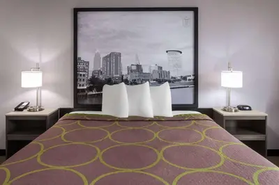 a hotel room with a bed with two lamps at Super 8 by Wyndham Copley Akron in Copley