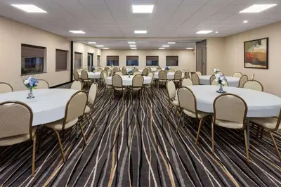 a conference room with white tables and chairs at Super 8 by Wyndham Copley Akron in Copley