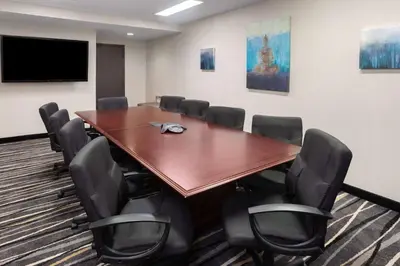 a conference room with a large wooden table and chairs at Super 8 by Wyndham Copley Akron in Copley