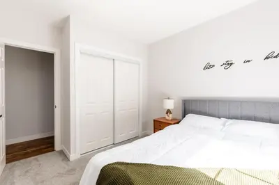 a white bedroom with a large bed and a closet at Spacious & Cozy Central Cincinnati Home in Cincinnati