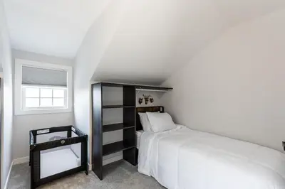 a white bedroom with a bed and a window at Spacious & Cozy Central Cincinnati Home in Cincinnati