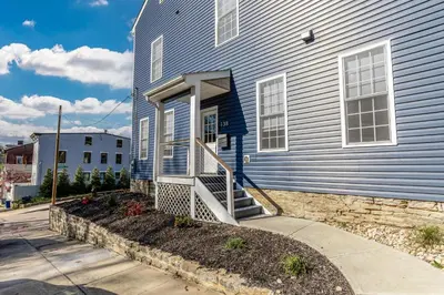a blue house with a staircase in front of it at Spacious & Cozy Central Cincinnati Home in Cincinnati
