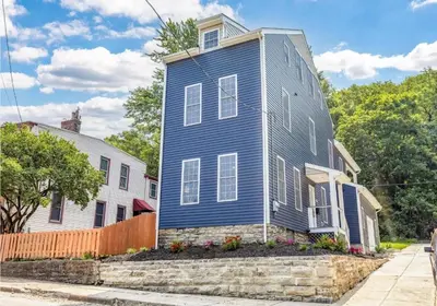 a blue house on the corner of a street at Spacious & Cozy Central Cincinnati Home in Cincinnati