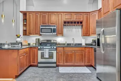 a kitchen with wooden cabinets and a stainless steel refrigerator at Lofts on 4th Penthouse, Sleeps 14, 2 units in Cleveland