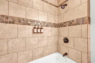 a bathroom with a tub with three bottles on the wall at Lofts on 4th Penthouse, Sleeps 14, 2 units in Cleveland
