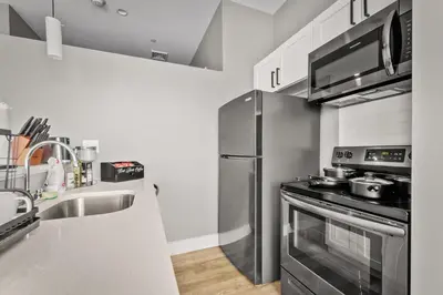 a kitchen with a stainless steel refrigerator and a sink at Modern 1 Bedroom Apartment with 2 TVs Fast WiFi and Free Parking in Cleveland