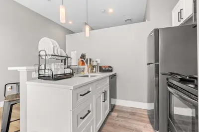 a kitchen with white cabinets and a stainless steel refrigerator at Modern 1 Bedroom Apartment with 2 TVs Fast WiFi and Free Parking in Cleveland