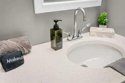 a bathroom counter with a sink and a bottle of soap at Modern 1 Bedroom Apartment with 2 TVs Fast WiFi and Free Parking in Cleveland