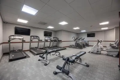 a gym with several treadmills and exercise bikes at Modern 1 Bedroom Apartment with 2 TVs Fast WiFi and Free Parking in Cleveland
